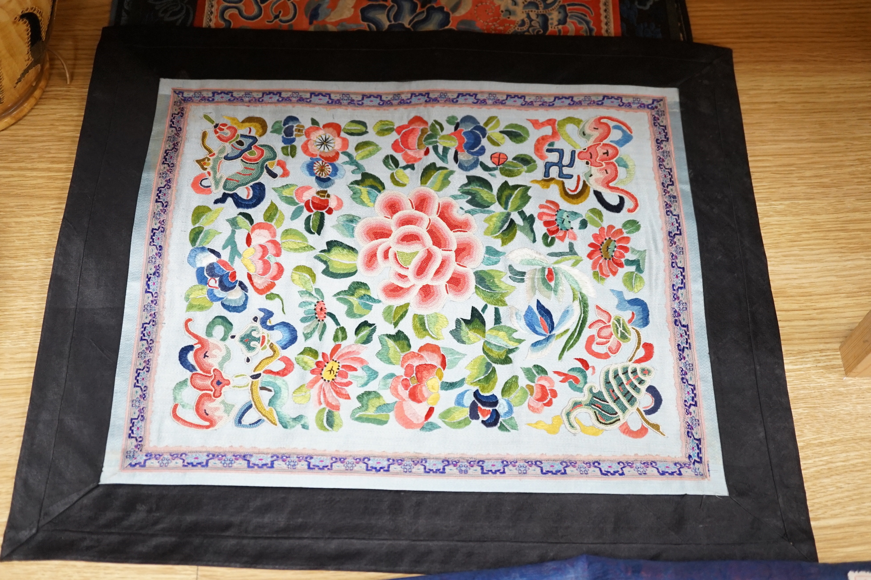 Six Chinese silk mats, embroidered with silk polychrome thread, all using mixed stitches including Beijing knot, five bordered with silk brocade, largest 43cm wide x 37cm high